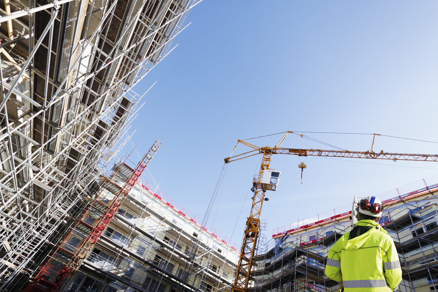 surveyor with instrument inside building-site, super wide view